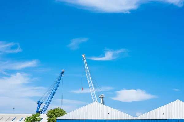 Blue and white cranes at a storage building