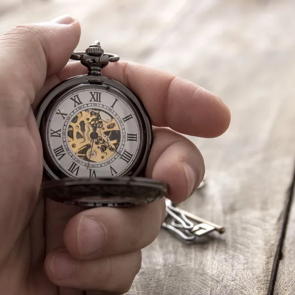 Hands with vintage pocket watch