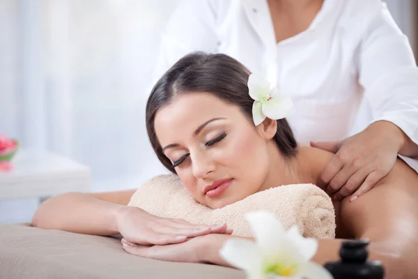 Beautiful woman having a wellness back massage at spa salon