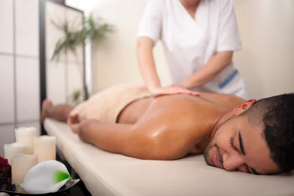 Masseur doing back massage on man body in the spa salon