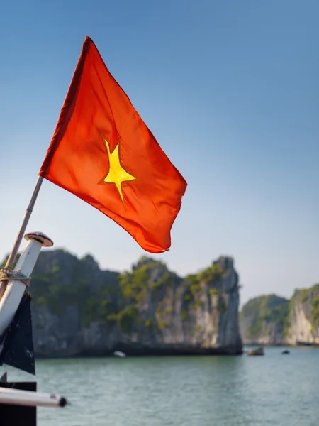 The flag of Vietnam on blue sky background, the Ha Long Bay