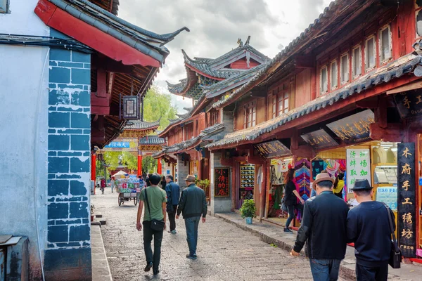 Asian tourists are walking on ancient street with souvenir shops