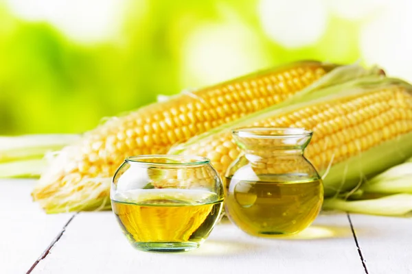 Corn oil and corn cobs on a garden table