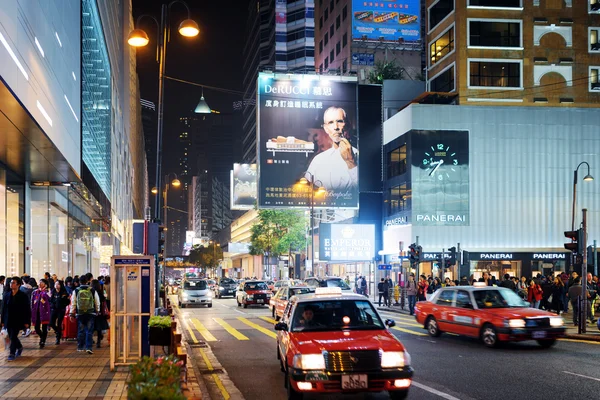 Taxi and illuminated signs on streets of night city Hong Kong