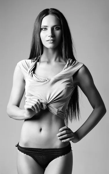 Studio fashion shot of pretty young woman in shirt and panties. Black and white