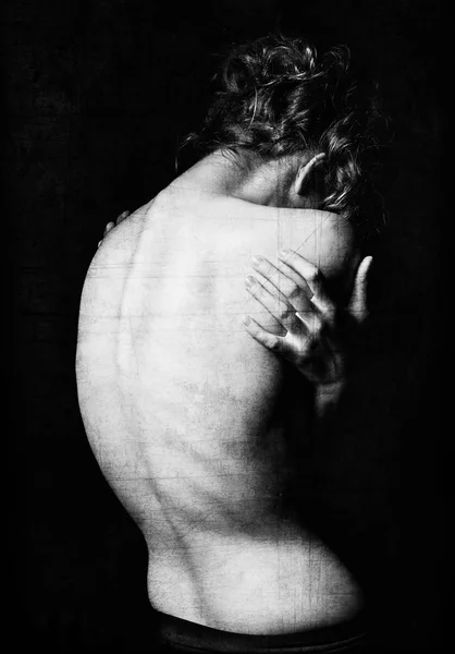 Spooky portrait of young woman among the dark. Grunge texture effect. Black and white, rear view