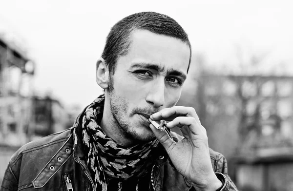 Closeup portrait of handsome smoking young man. Black and white