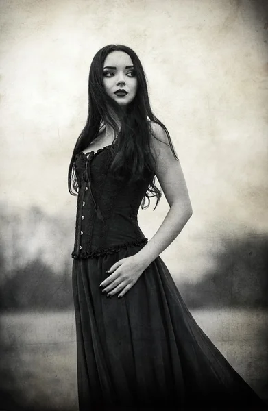 Portrait of beautiful sad goth girl. Grunge texture effect