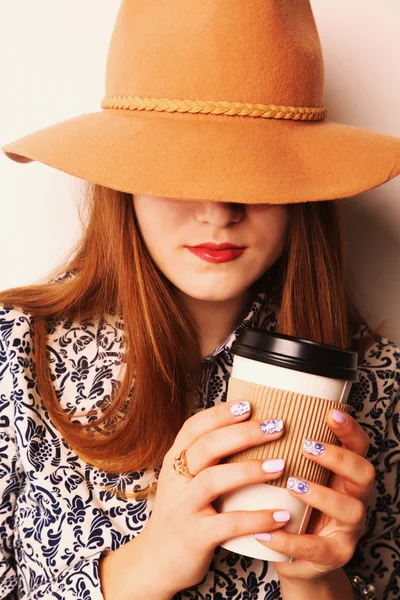 The girl cowboy in hat with coffee