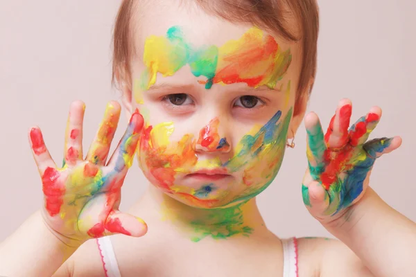 Happy cute little girl with colorful painted hands