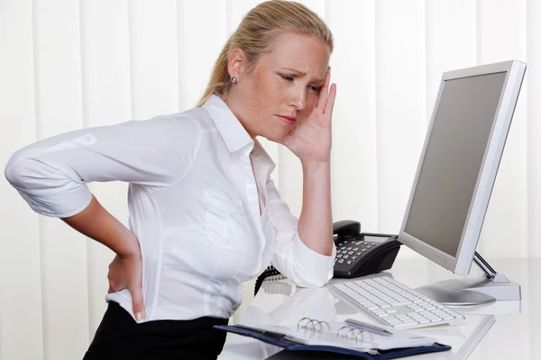 Woman with back pain in the office