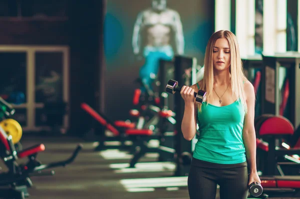 Woman doing biceps workout with dumbbell