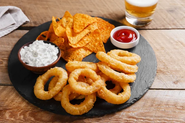 Fried onion rings in batter with sauce tortilla chips