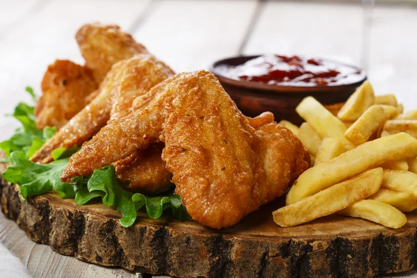 Fried chicken wings with sauce and French fries