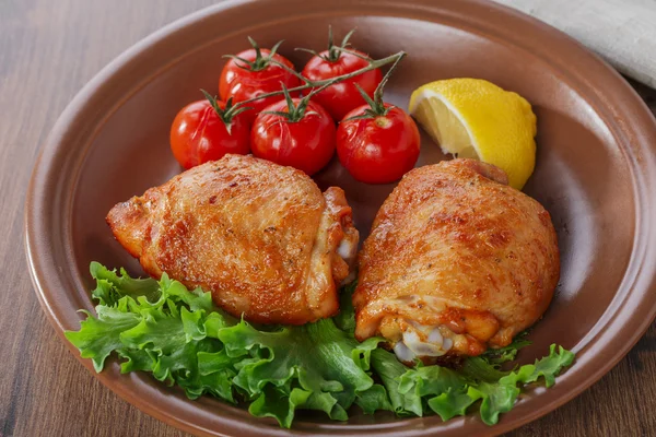 Baked chicken thigh with cherry tomatoes and lemon
