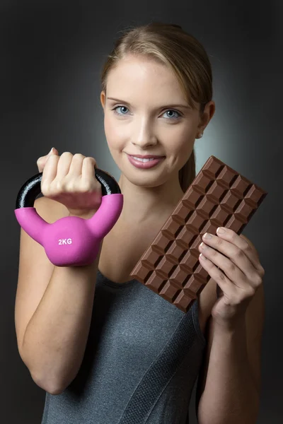 Fitness model with kettlebell and chocoalte