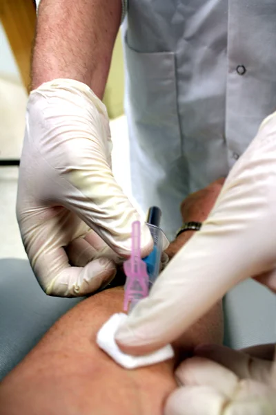 Phlebotomist drawing a blood sample from a patient\'s arm.