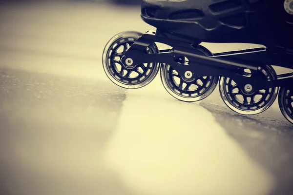 Road and wheels of roller skates closeup