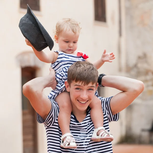 Portrait of cheerful and happy big brother and little sister, outdoor,