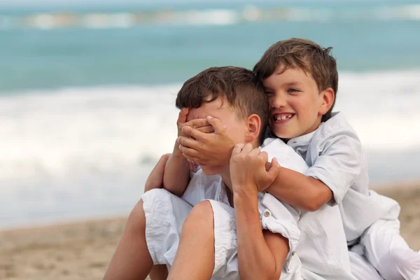 Portrait of happy brothers in white shirts on background of sea