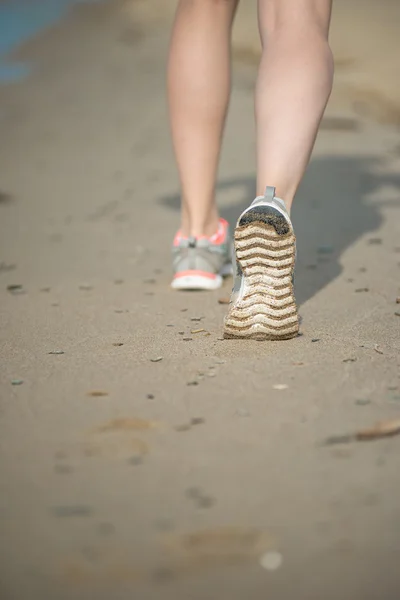 Sport footwear, sand footprints and legs close up. Runner feet d
