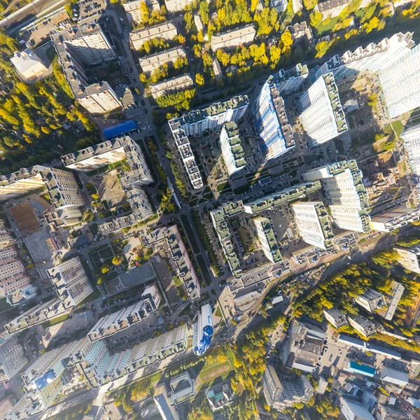 Aerial city view with crossroads, roads, houses, buildings and parks .