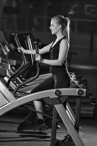 Young woman at the gym exercising. Run on machine.