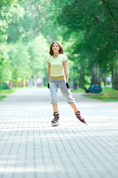 Sporty girl in park on inline skate