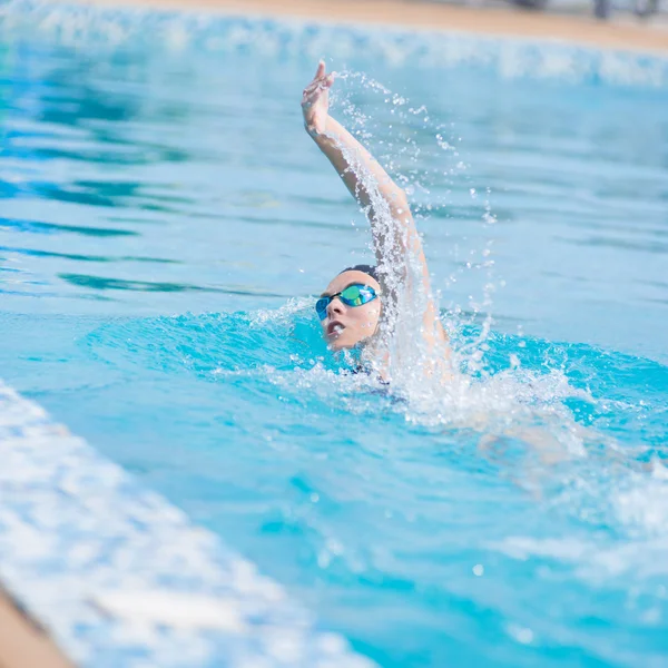 Woman in goggles swimming front crawl style