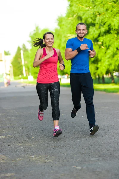 Runners training outdoors working out. City running couple jogging outside.