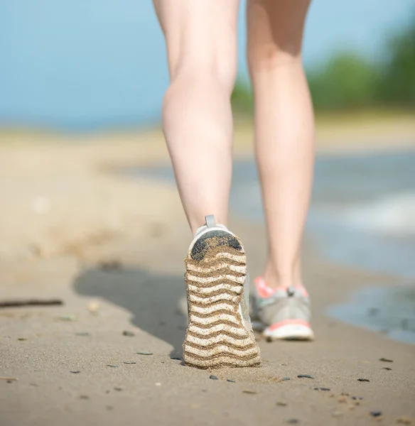 Sport footwear, sand footprints and legs close up. Runner feet d