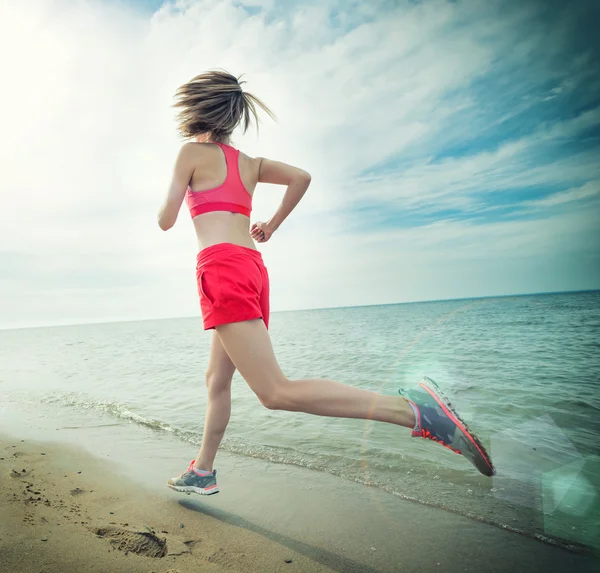 Young lady running at the sunny summer sand beach. Workout.  Jog