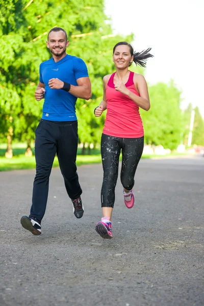 Runners training outdoors working out. City running couple jogging outside.