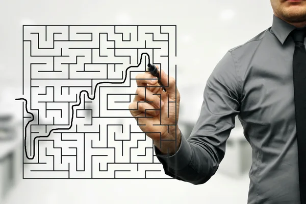 Conceptual image of businessman trying to find way out of maze