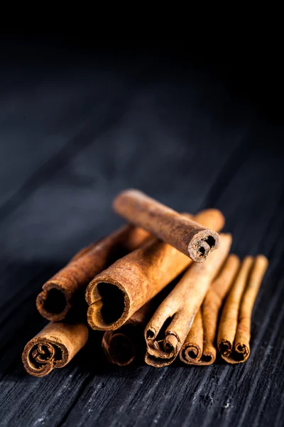 Cinnamon sticks on black wood board