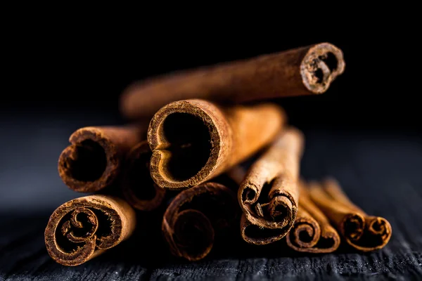 Cinnamon sticks on black wood board