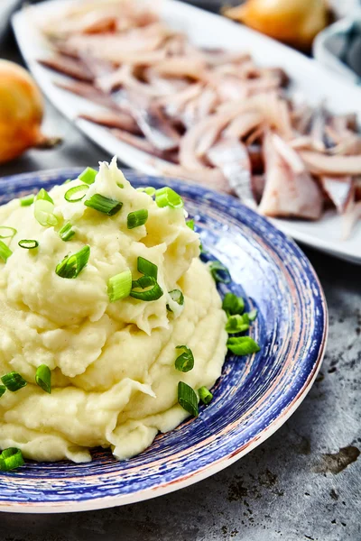 Mashed potatoes with herring and pickled onions
