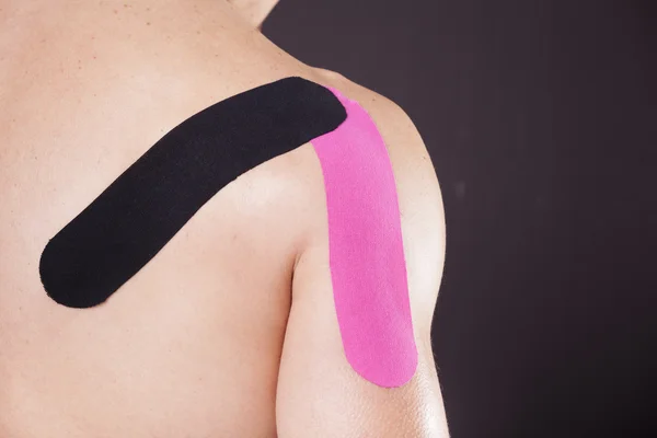 Muscular man with kinesiotaping on the shoulder