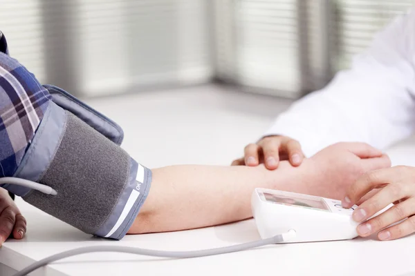 Doctor measuring blood pressure of a woman