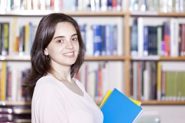 Female student holding books at the library