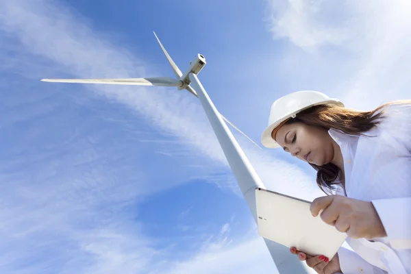 Environmental engineer with a tablet computer at wind farm