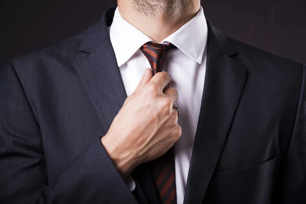 Man in a suit fixing his tie