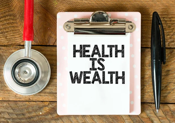 Clipboard with health is wealth inscription