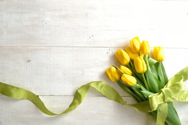 Yellow tulips bouquet with yellow green ribbon