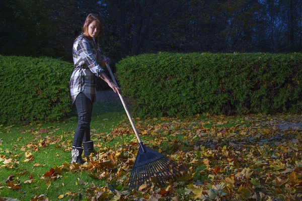 Young woman raking leaves