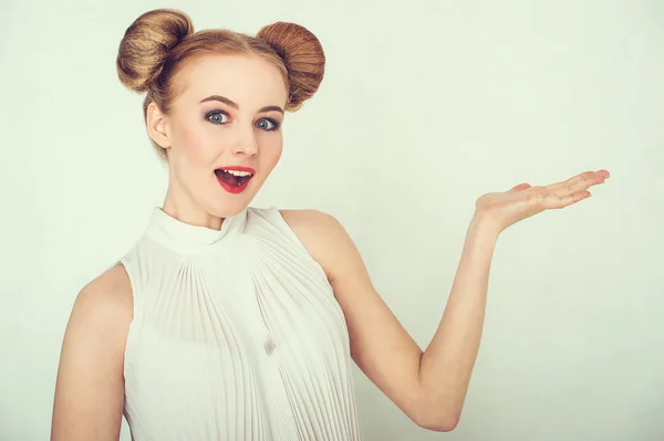 Close-up portrait of surprised beautiful girl. with funny hairstyle, open hand and open-mouthed.