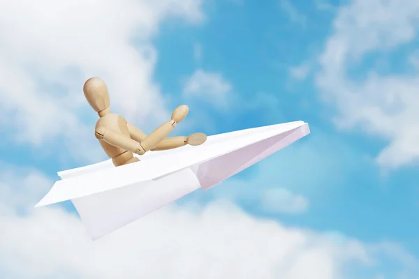 Man flying in a toy paper plane. Abstract image with a wooden puppet