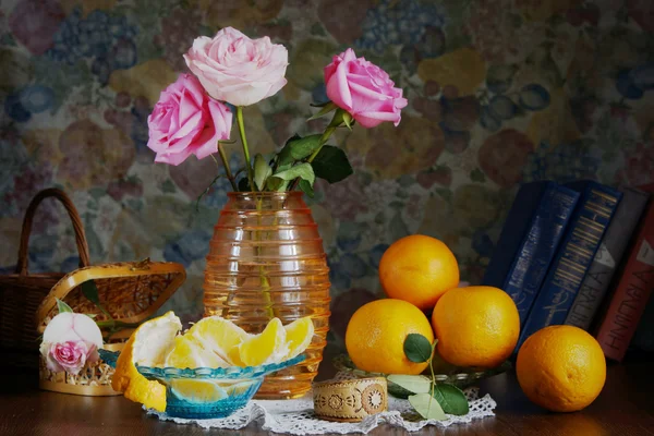 Rural still life with roses in a vase and oranges