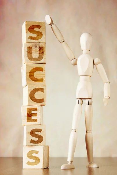 Man achieves success. Conceptual image with wooden dummy