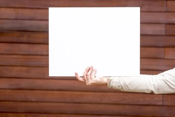 Woman outside with a blank white card